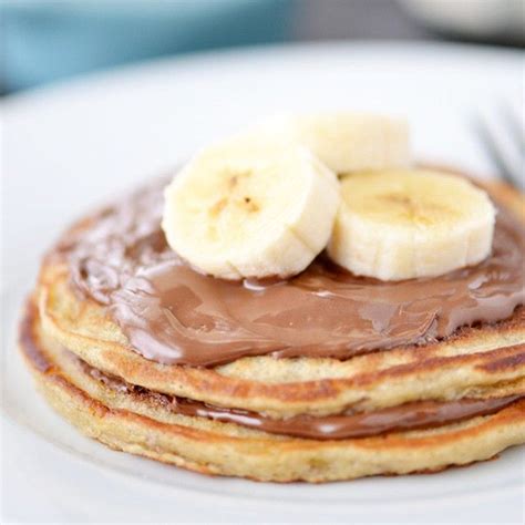 Chocolate And Banana Pancakes On A White Plate With Syrup Drizzled Over