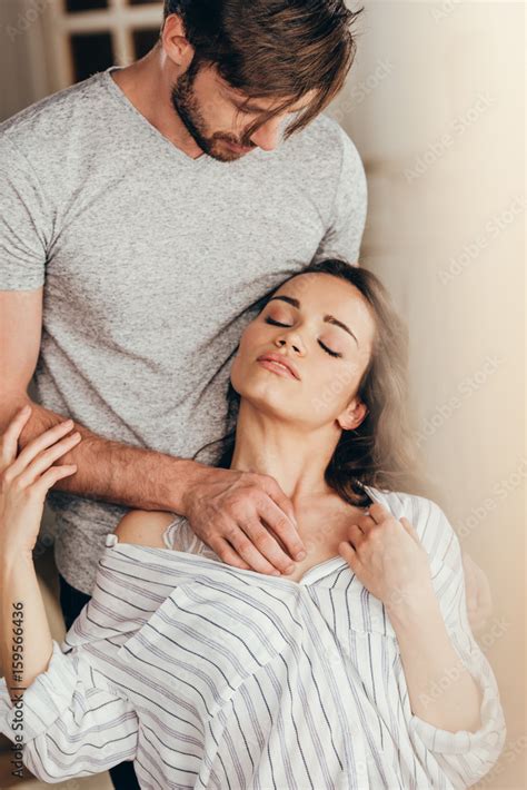 Man Touching Chest Of Young Sensual Woman In Foreplay At Home Stock