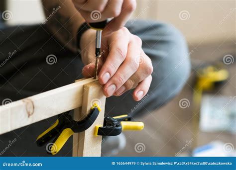 Young Carpenter Handyman Working With Wood Using A Screwdriver Stock