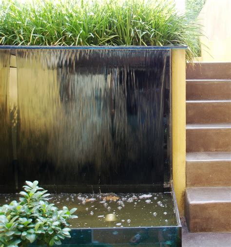 garden with glass water wall and polished concrete steps simon scott landscaping