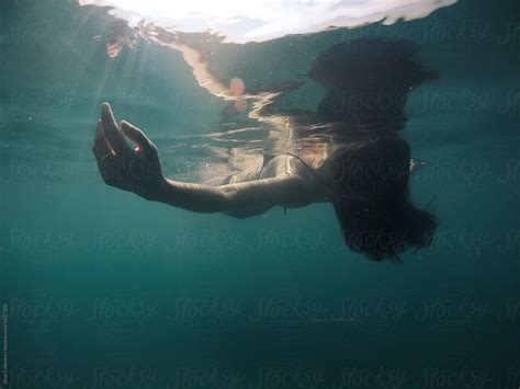 Peaceful Woman Floating In The Water From Underwater View Del