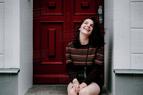 Laughing Caucasian Woman Sitting In Doorway Stock Photo Dissolve