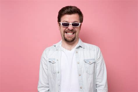 Young Handsome Man In Sunglasses Smiling On Pink Wall Stock Photo