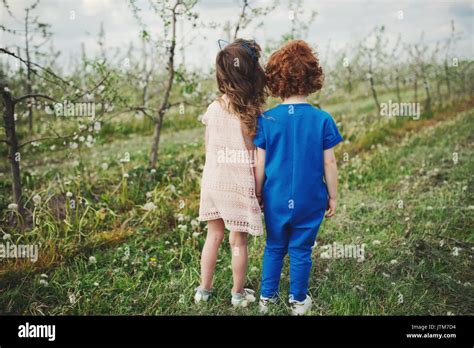 Little Boy And Girl In Blooming Garden Stock Photo Alamy