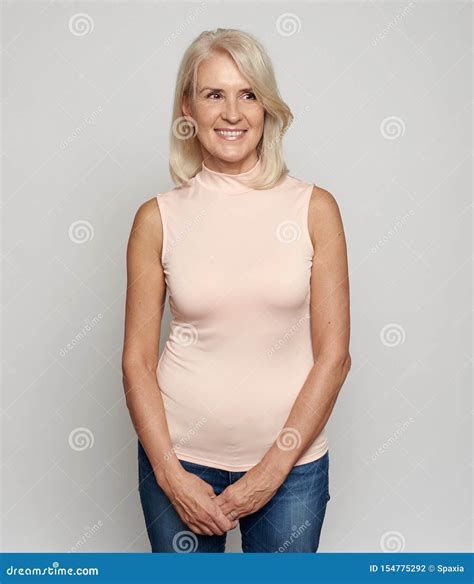 Beautiful 50 Years Old Woman Is Smiling Isolated On Grey Stock Photo