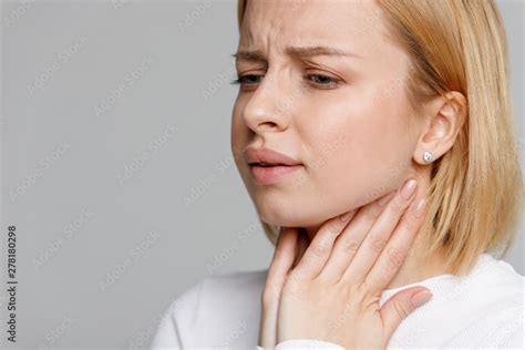 Closeup Of Sick Young Woman Suffering From Throat Problems Holding