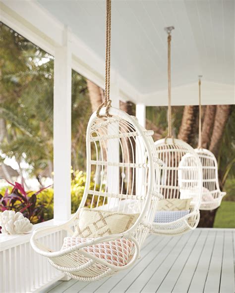 Two White Hanging Chairs On A Porch