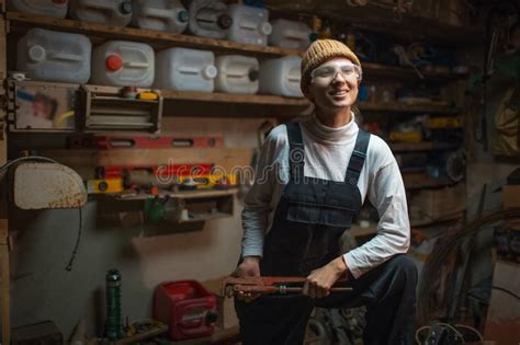 Portrait Of Smiling Young Builder Girl Standing In Old Workshop Room