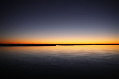 Free Photo Silhouette Of Calm Sea Under Blue And Orange Clear Sky