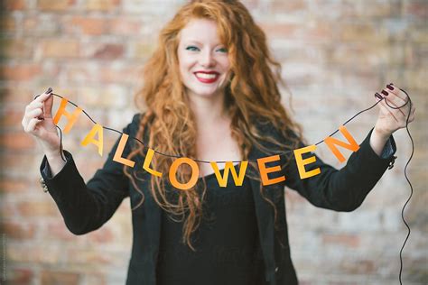 Smiling Ginger Woman Holding Halloween Decoration By Stocksy Contributor Lumina Stocksy