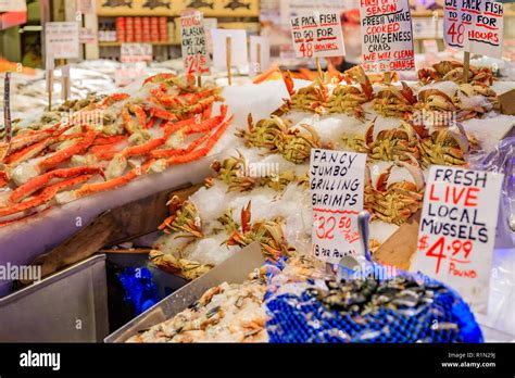Fishmonger At A Stall With Fresh Seafood Like Crab Shrimp And Mussels