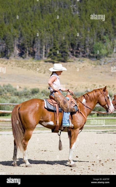 Woman Western Style Rider On A Horse Wearing A Hat Chaps And Kinks Side