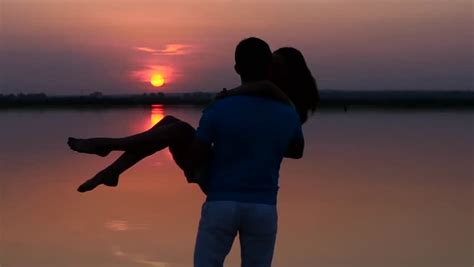 slowmotion couple embracing at sunset silhouettes of men and women on the beach the couple