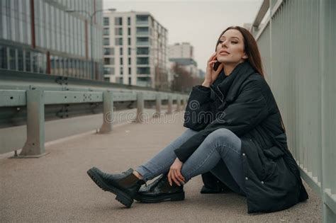 Fashionable Relaxed Young Woman Sitting On Sidewalk Near Road Urban Fashion Concept Street