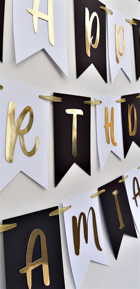 Gold Foiled Letters Are Hung On Black And White Buntings That Spell Out