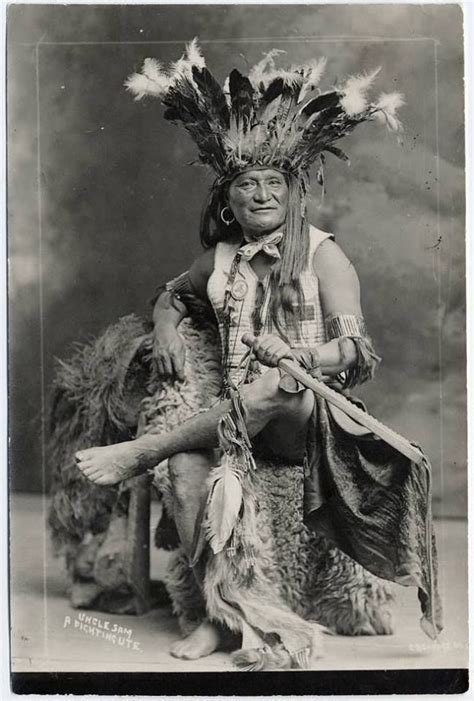 An Old Black And White Photo Of A Native American Man With Feathers On