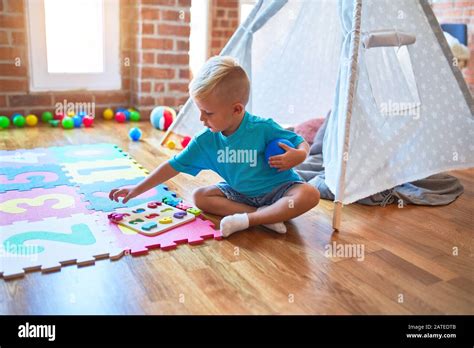 Young Caucasian Kid Playing Placing Numbers At Kindergarten