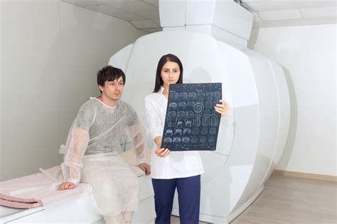 Confident Pleasant Female Doctor Working With Mri Scan Results And Tells The Patient The