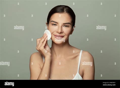 Young Brunette Woman Removing Makeup From Her Face With Cotton Pads