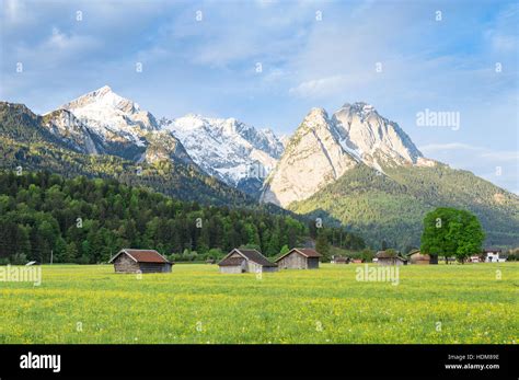 Bavarian Serene Landscape With Snowy Alps Mountains Ridge And Spring