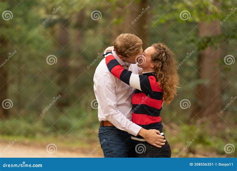 Beautiful Young Couple Is Kissing In The Forest Arms Around Each Other Stock Image Image Of