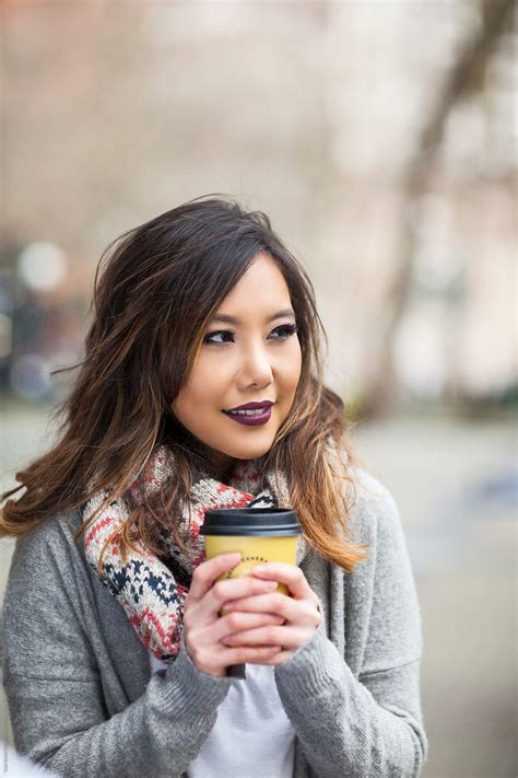 "Beautiful Asian Woman Holding A Coffee Cup In An Urban Area" by