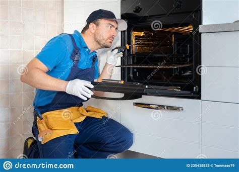 One Repairman Fixing Malfunctioning Kitchen Oven Problem Stock Photo