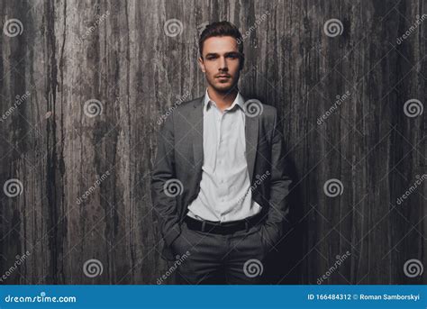 Handsome Businessman In Gray Suit Holding Hands In Pockets Stock Photo