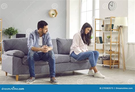 Couple Sitting On Opposite Sides Of The Sofa At Home Quarrel And