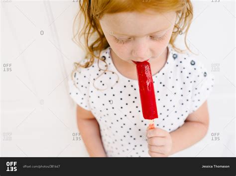 Little Girl Eating A Red Frozen Popsicle Stock Photo Offset