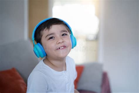 Portrait Of Happy Child Wearing Headphones And Looking Up With Smiling