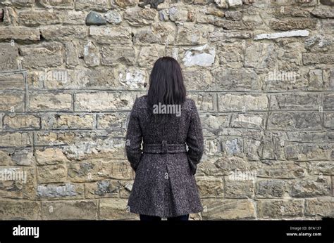 Young Woman Facing Stone Wall Stock Photo Alamy