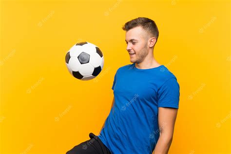 Premium Photo Young Handsome Blonde Man Holding A Soccer Ball Over