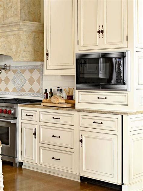 White and black distressed kitchen cabinets in this large traditional kitchen. All About Cabinetry