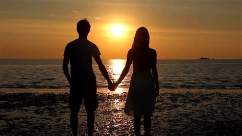 Silhouetted Couple Holding Hands On The Beach In The Sunset Stock Footage Video 3632810