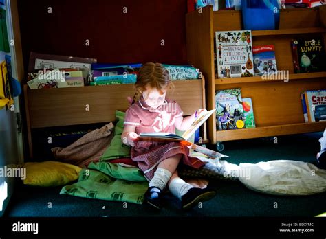 Girl Reading Alone In A Primary School Classroom Stock Photo Alamy