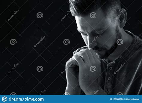 Man With Hands Clasped Together For Prayer On Dark Background Black