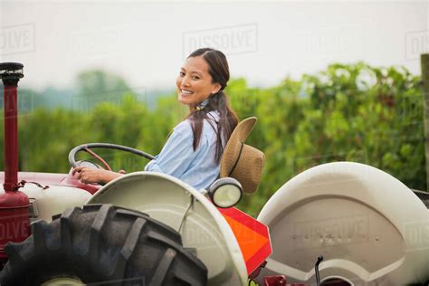Asian Woman Driving Tractor In Field Stock Photo Dissolve