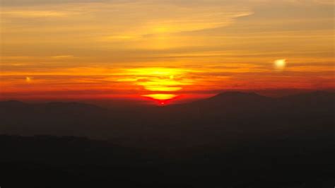 Download Wallpaper 1366x768 Sunset Horizon Glow Mountains Clouds