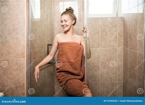 A Sexy Young Girl Takes A Shower In The Bathroom On A Brown Tile Background The Attractive