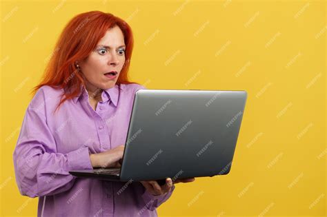 premium photo redheaded mature woman with a surprised look using a laptop