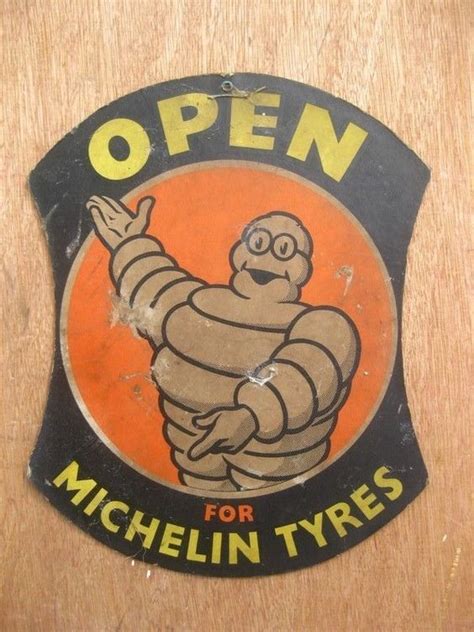 An Old Style Sign That Says Open For Michel Tyres