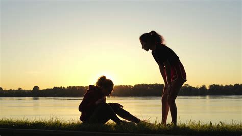 Silhouette Of Girl Giving Helping Hand To Her Friend During Training