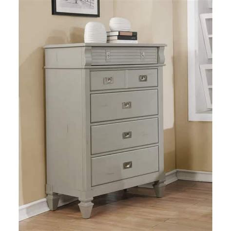 A Gray Dresser With Drawers And Two White Vases On Top