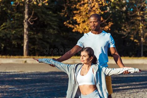Boyfriend Helping Stretching His Girlfriend On A Road Stock Photo