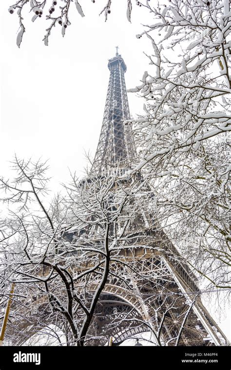 Winter In Paris In The Snow Low Angle View Of The Eiffel Tower Through