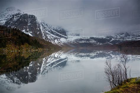 Reflection Of Snowy Rugged Mountains In Water Storvatnet Lofoten