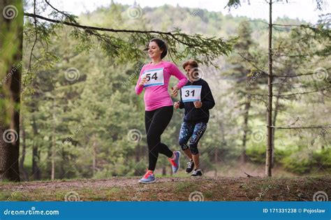 Pregnant Woman Running A Race Competition In Nature Stock Photo