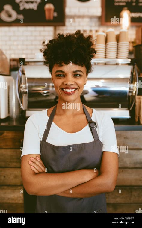Confident Female Barista Standing In Front Of A Cafe Counter Woman