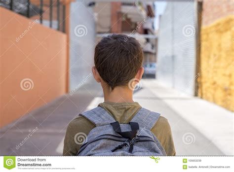 Teenage School Boy With A Backpack On His Back Walking To School Stock